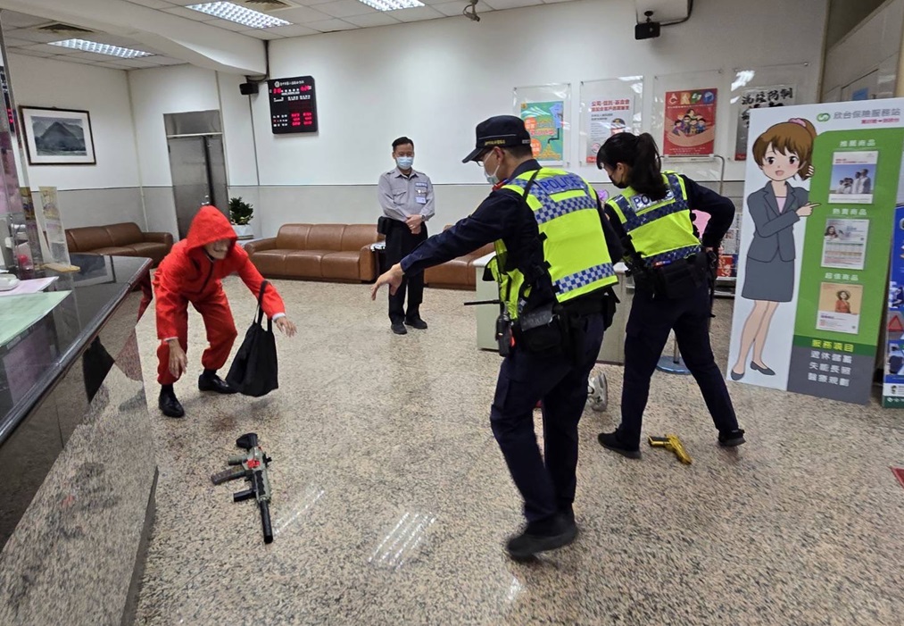 ▲圖說：警方接獲銀行報案，員警「荷槍實彈」，以優勢警力衝入銀行壓制劫匪棄械投降 （圖／台中市政府提供）