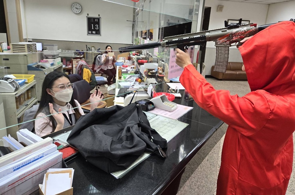 ▲圖說：歹徒一聲令下「不要動」，並要求行員將現金裝進黑色袋子             （圖／台中市政府提供）