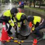 ▲圖說：中市文心南七路上人孔蓋扛不住水流而浮起，南屯所員警緊急以三角錐警示，並重新將人孔蓋固定 （圖／台中市政府 提供）