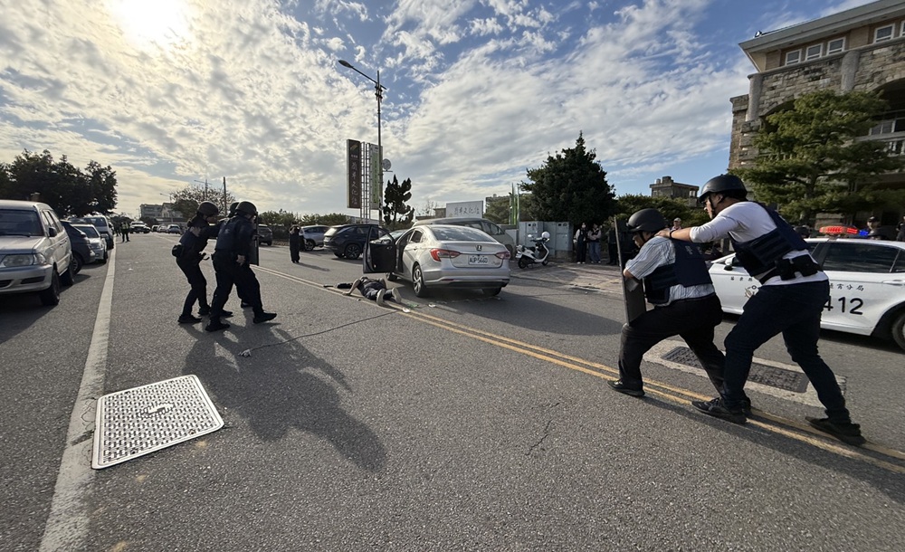 ▲圖說:「搶匪」駕駛自小客車經過警方設置攔截點,員警上前將歹徒壓制上銬逮捕 苗栗縣政府 提供)